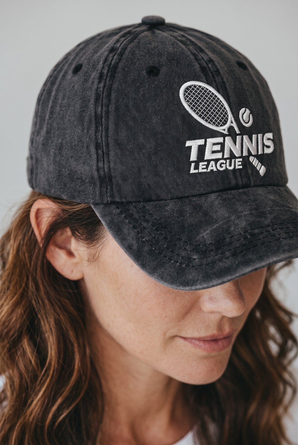 Tennis League Hat worn by a model, front view