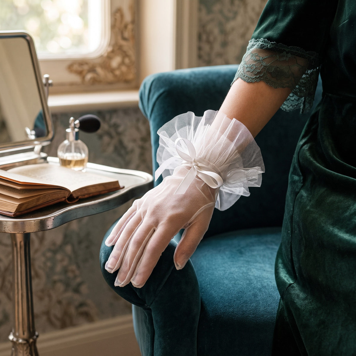 Sheer white tulle wrist gloves with a pleated tulle ruffle cuff and a satin bow.