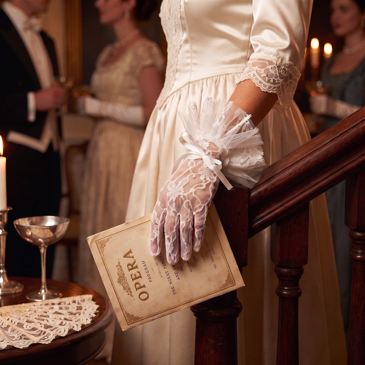 White lace wrist gloves with a soft tulle bow cuff and a single pearl.