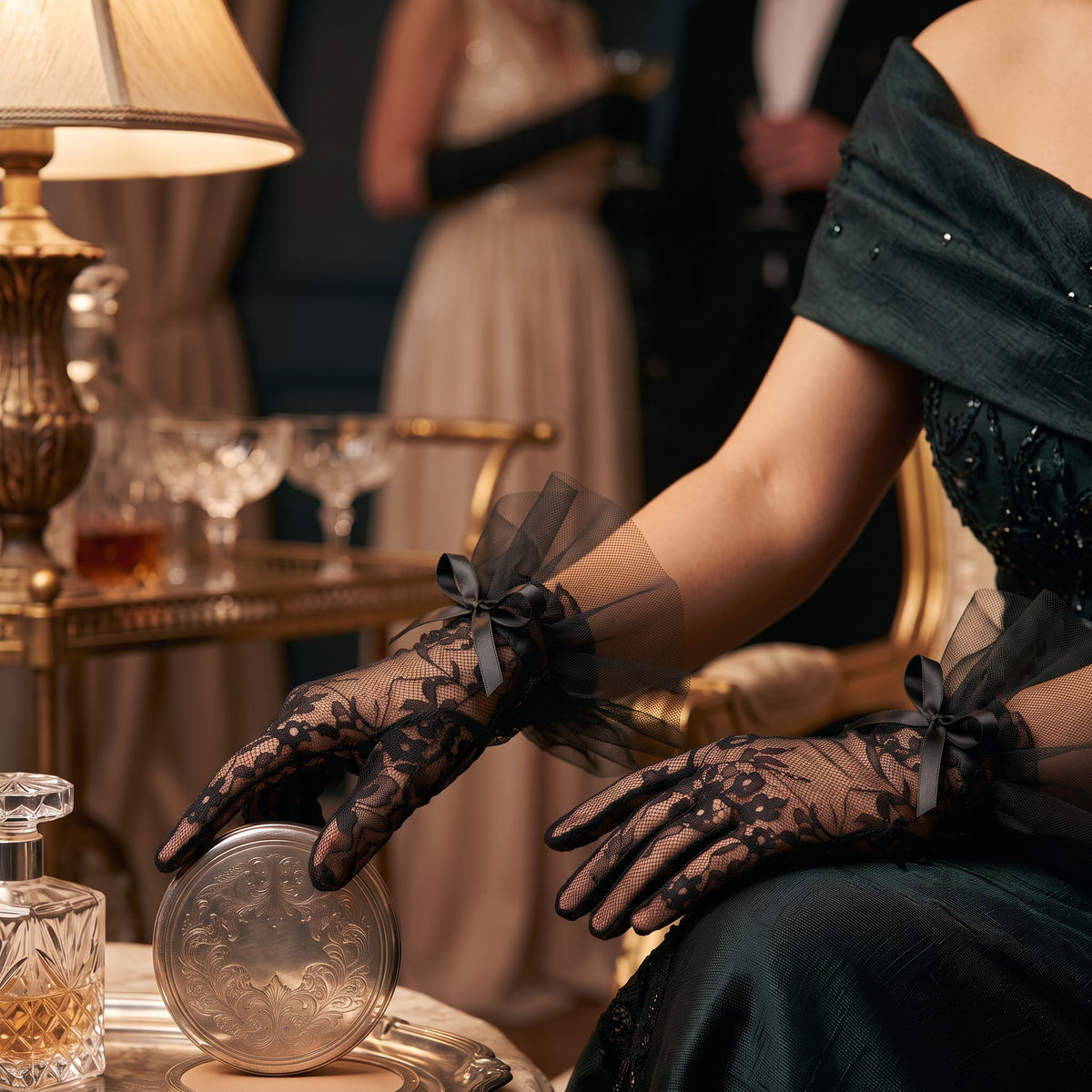 Black floral lace wrist gloves with a black tulle ruffle cuff and satin bow.