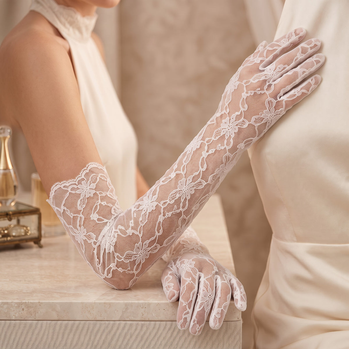 Above-elbow white gloves in a bold open floral lace, fingers covered.