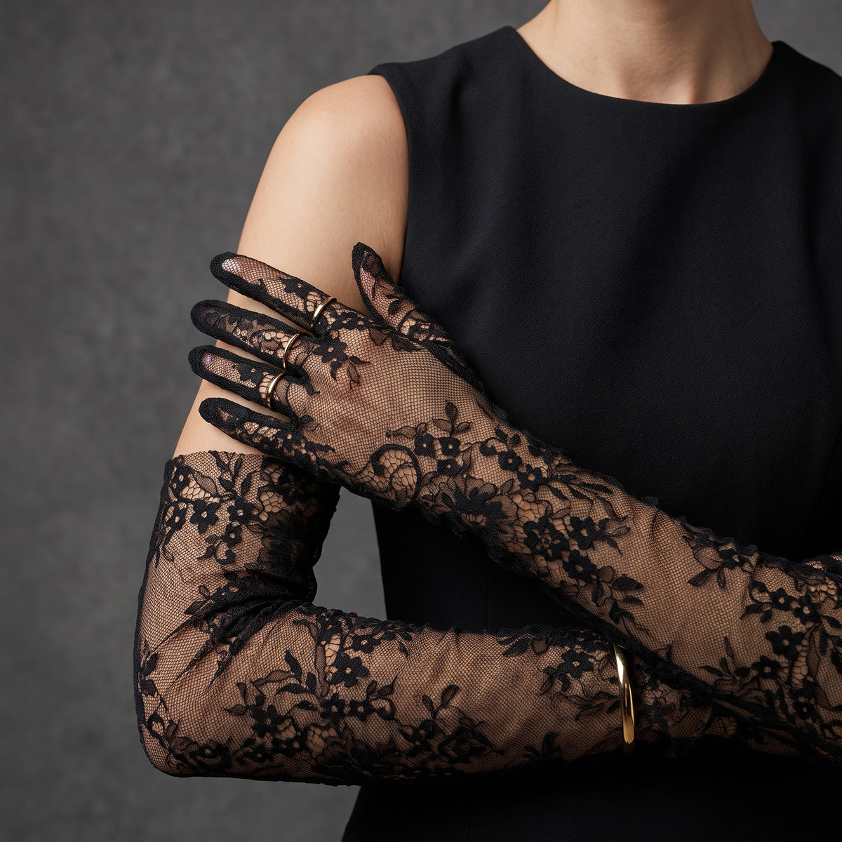 Above-elbow black floral lace gloves with scalloped fingertips.
