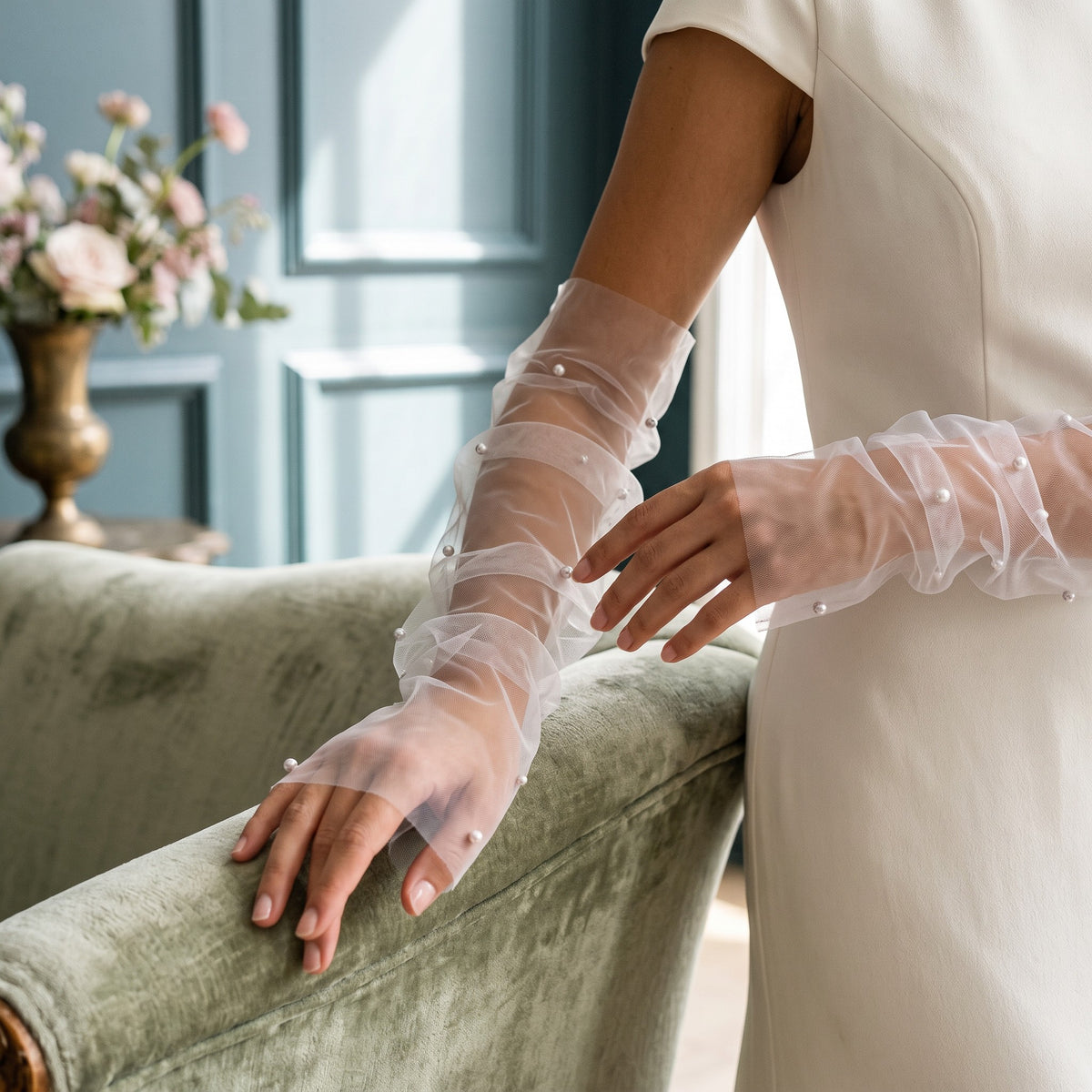White tulle arm cuffs with scattered pearls and a ruffle edge, fingerless.