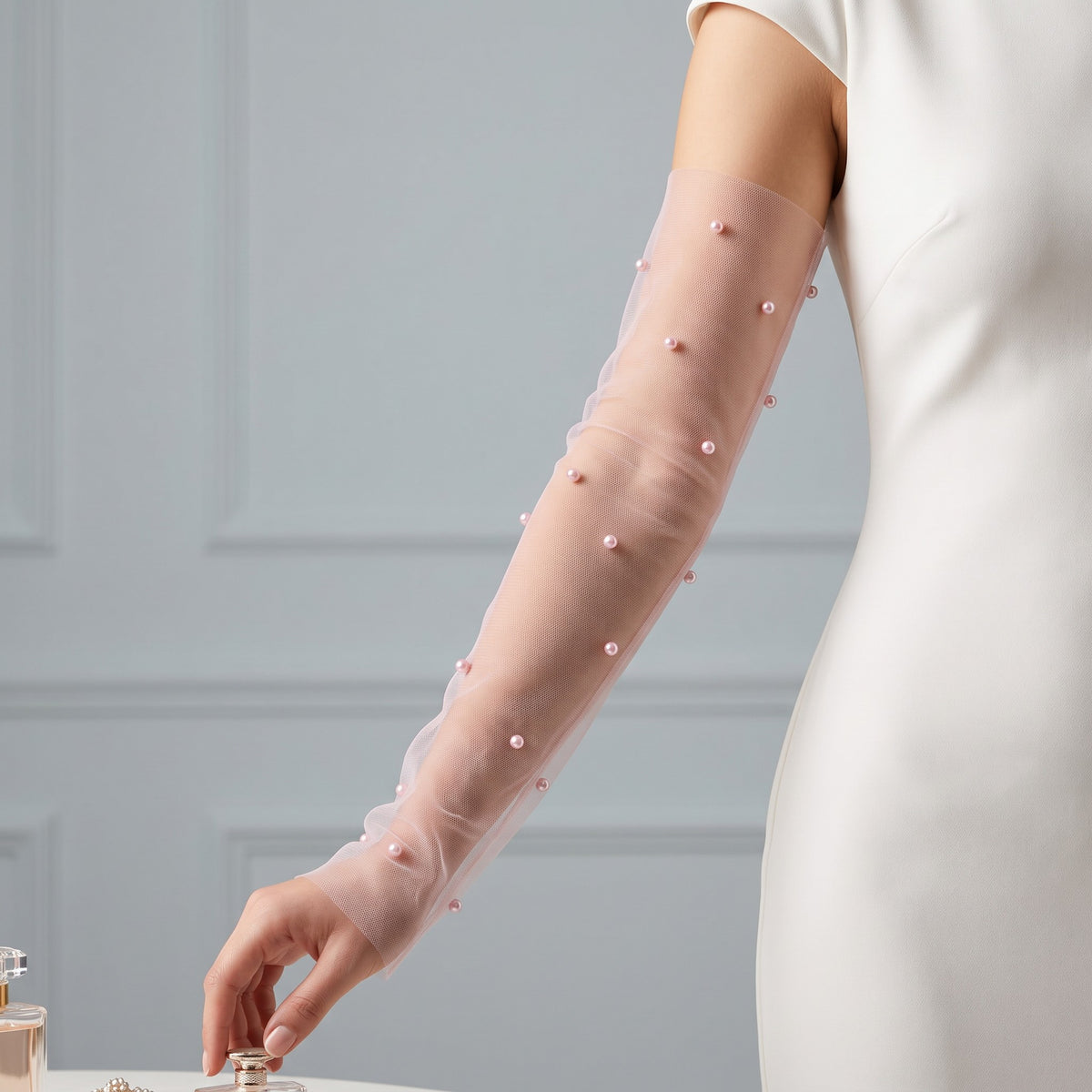 White tulle arm cuffs set with larger pearls, fingerless, densely ruched.
