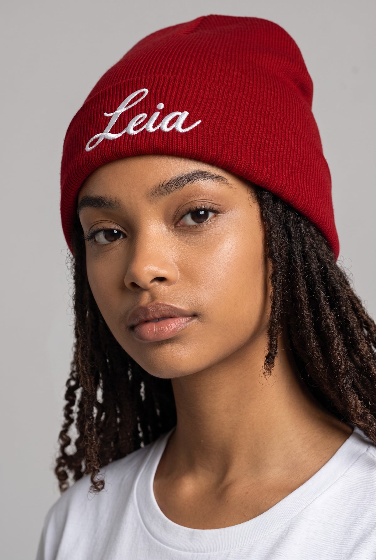 Model wearing a red Eddia beanie with custom cuff embroidery