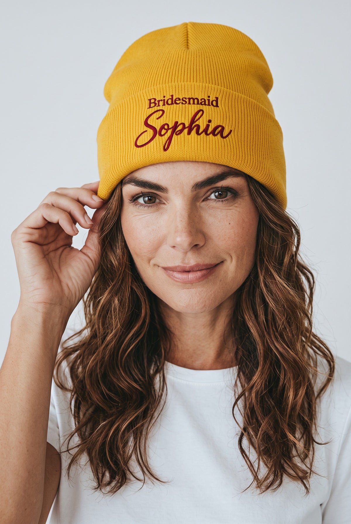 Model wearing a yellow Eddia beanie with custom cuff embroidery