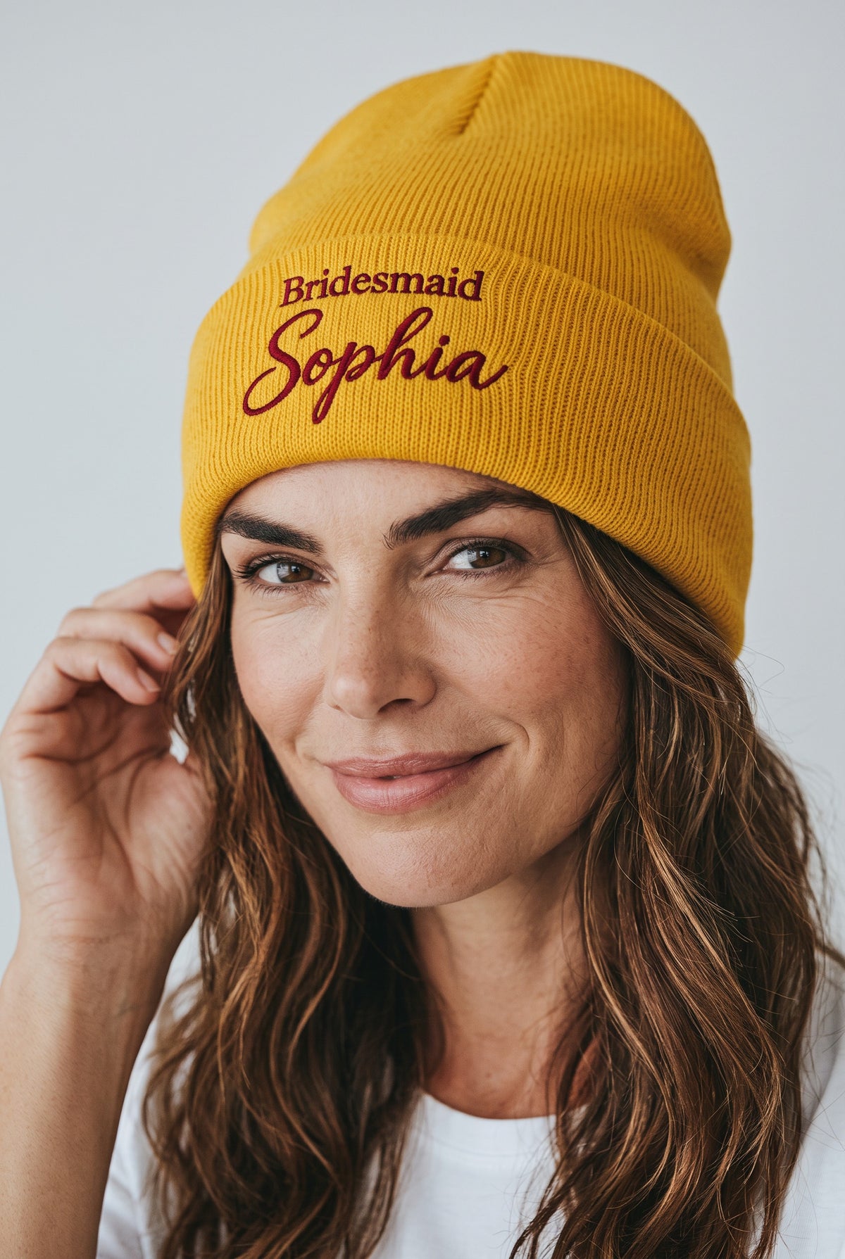 Model wearing a yellow Eddia beanie with custom cuff embroidery