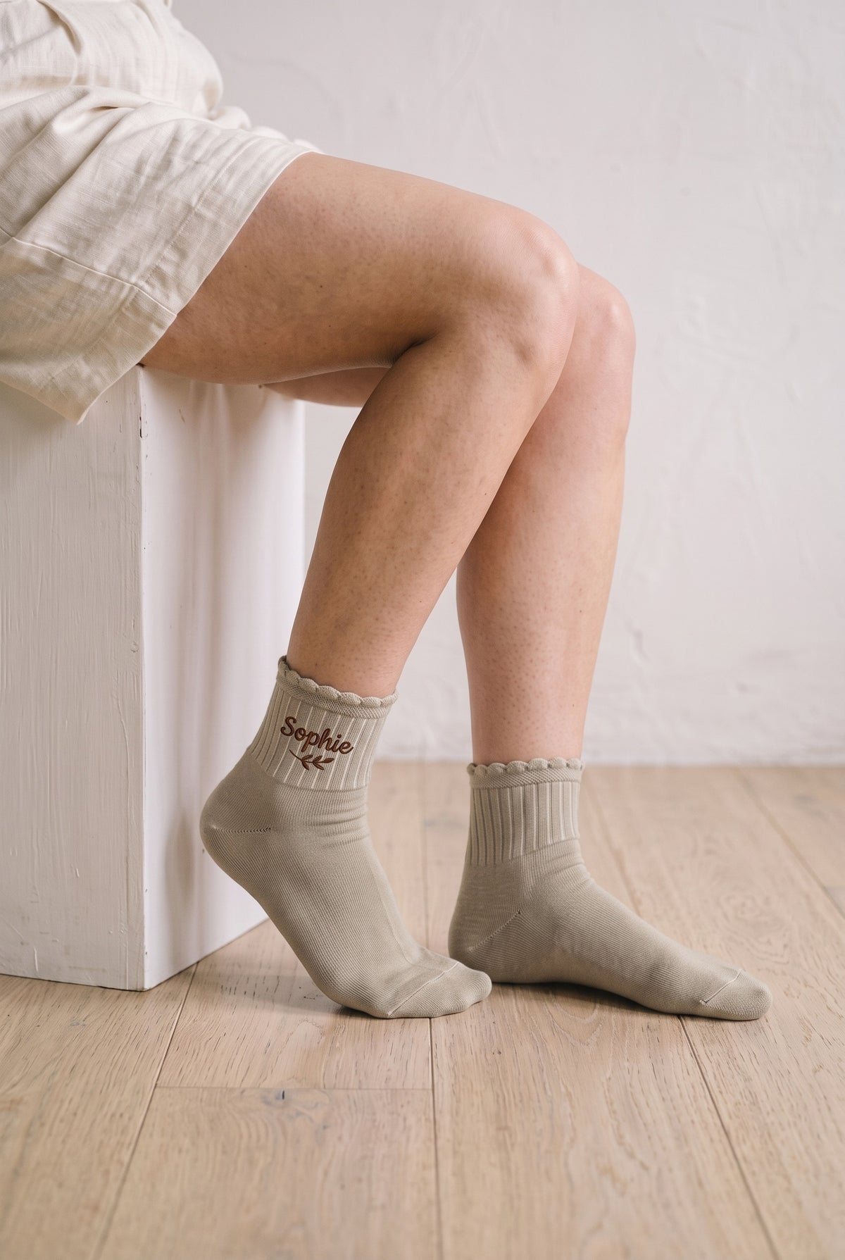 Model wearing beige embroidered ruffle ankle socks