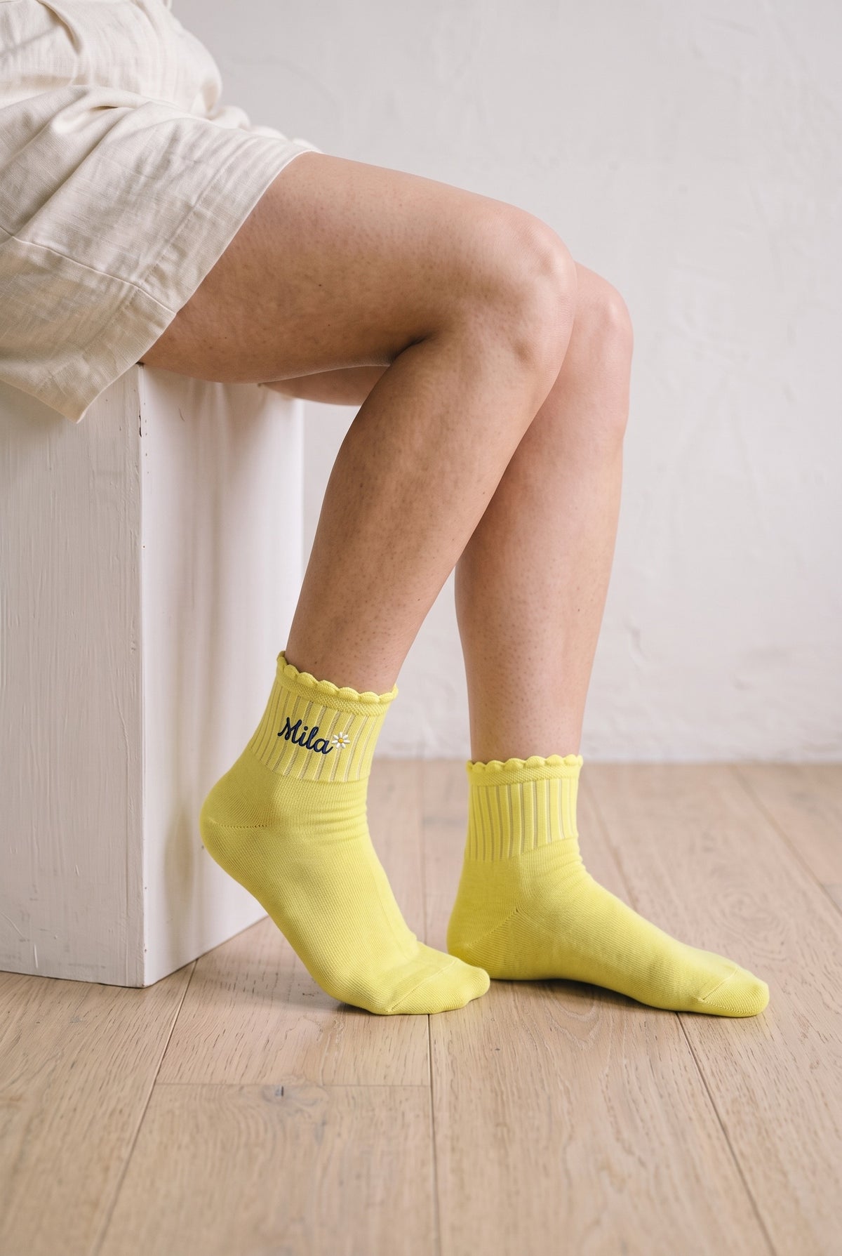 Model wearing lemon yellow embroidered ruffle ankle socks