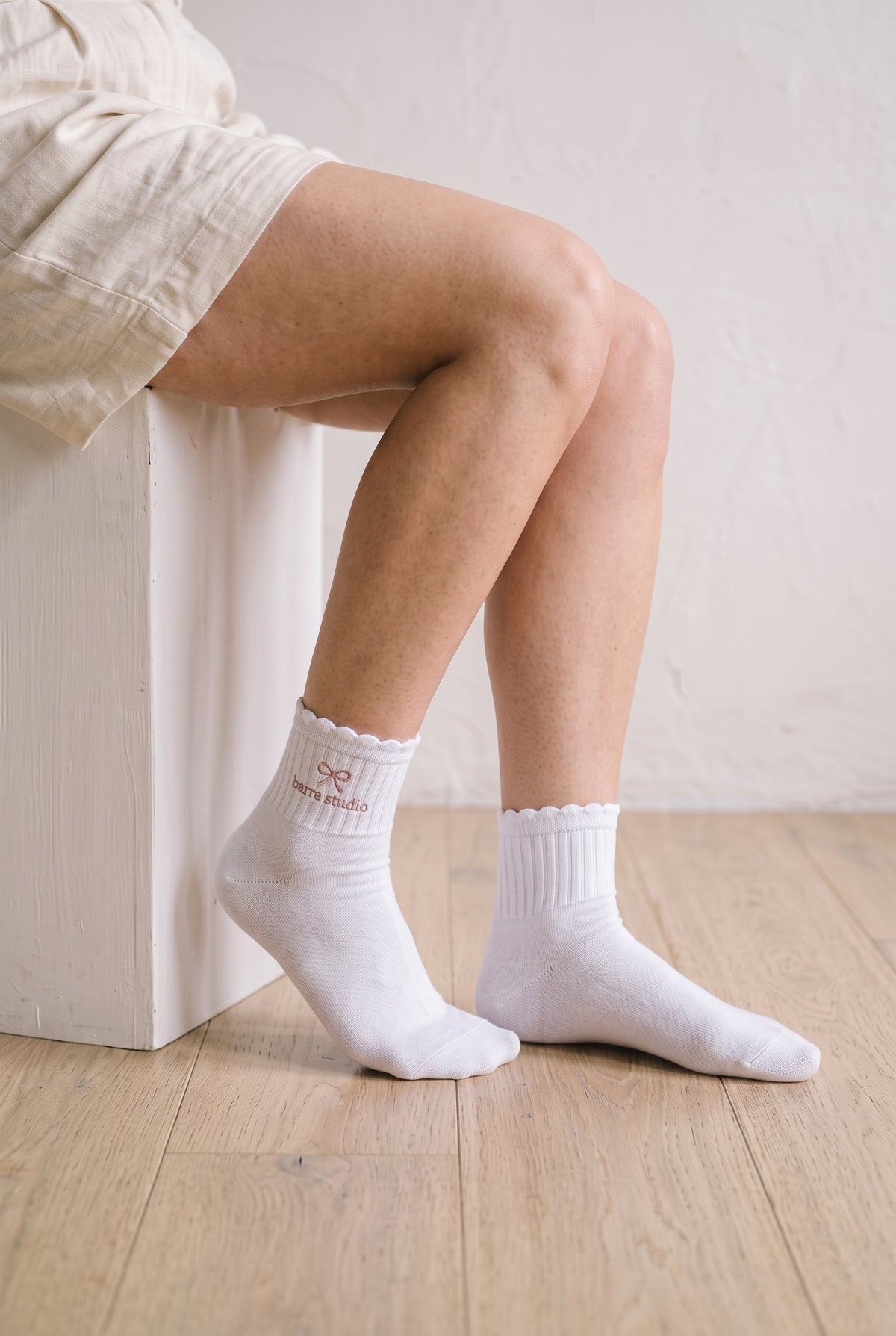 Model wearing white melange embroidered ruffle ankle socks