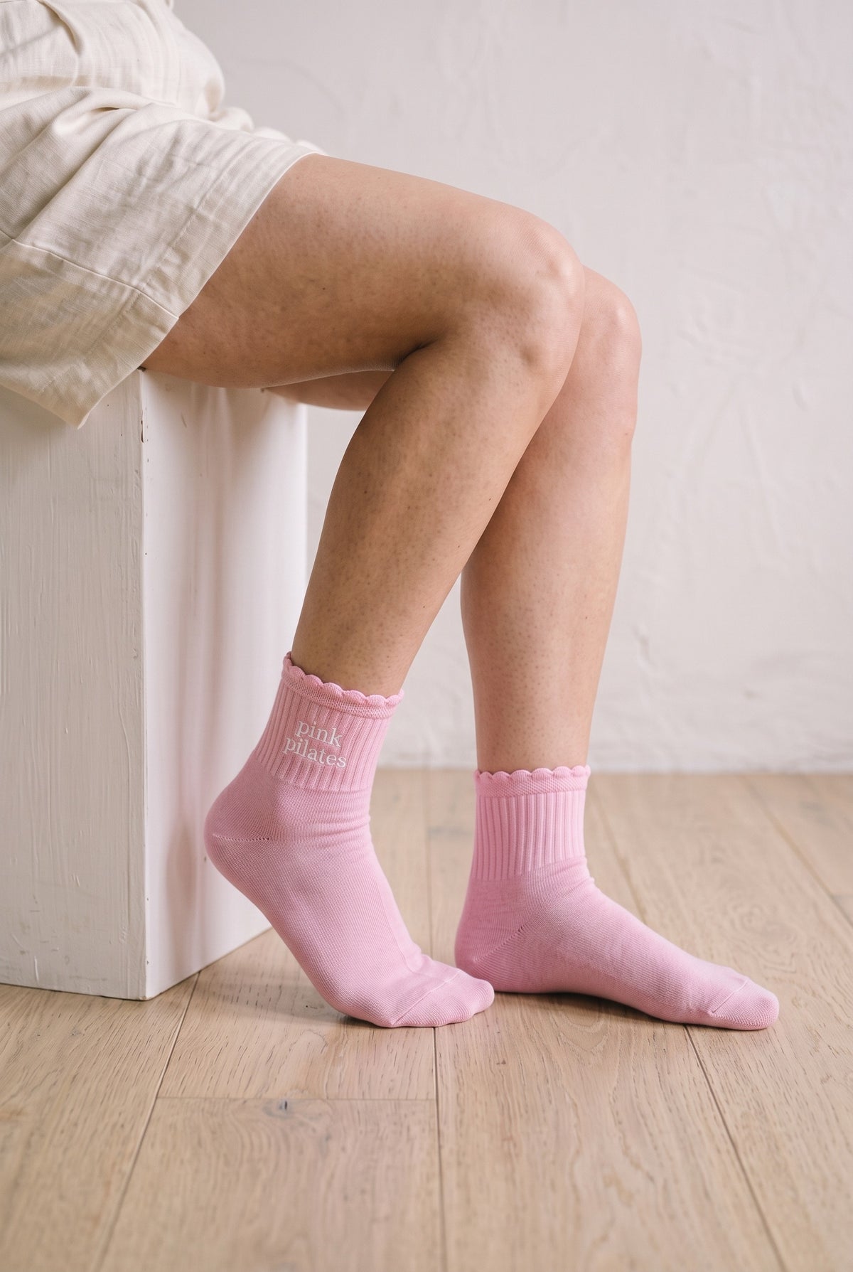 Model wearing orchid embroidered ruffle ankle socks