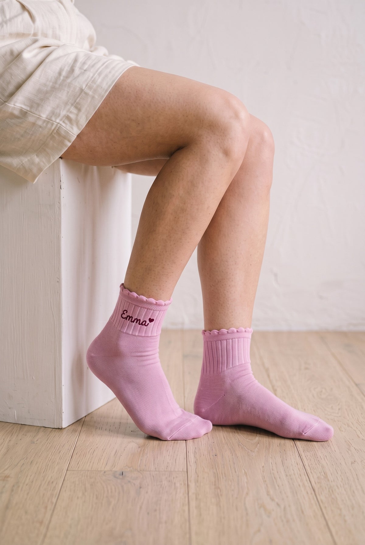 Model wearing pink embroidered ruffle ankle socks