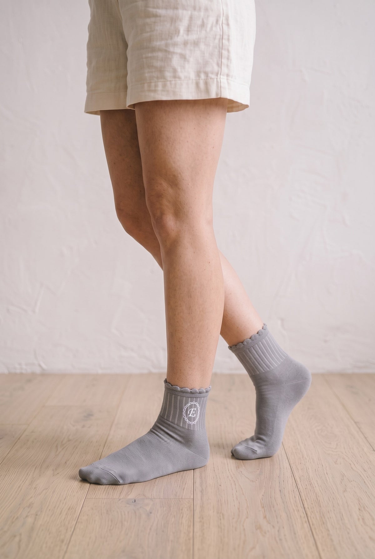Model wearing grey embroidered ruffle ankle socks, second view