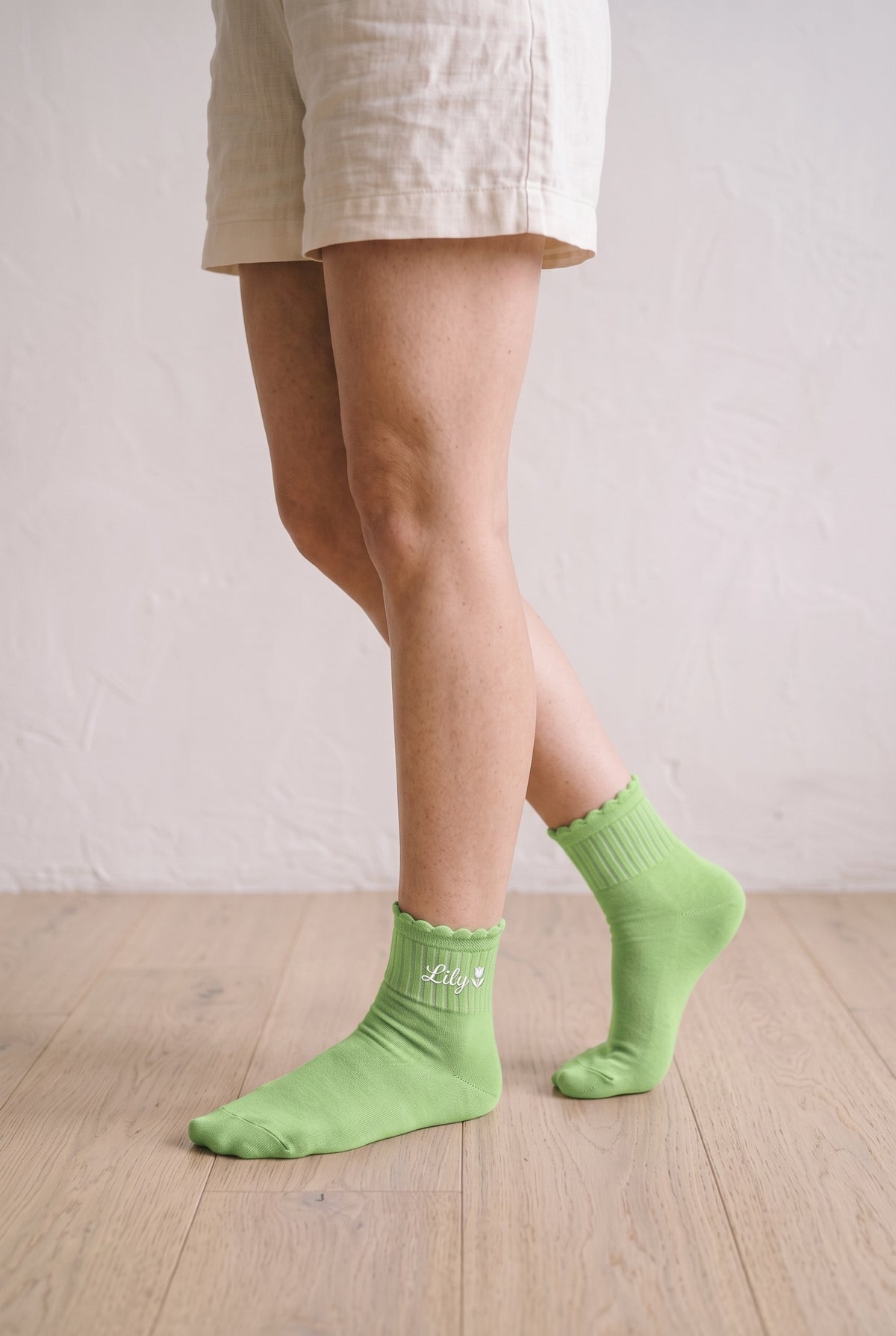 Model wearing pistachio green embroidered ruffle ankle socks, second view