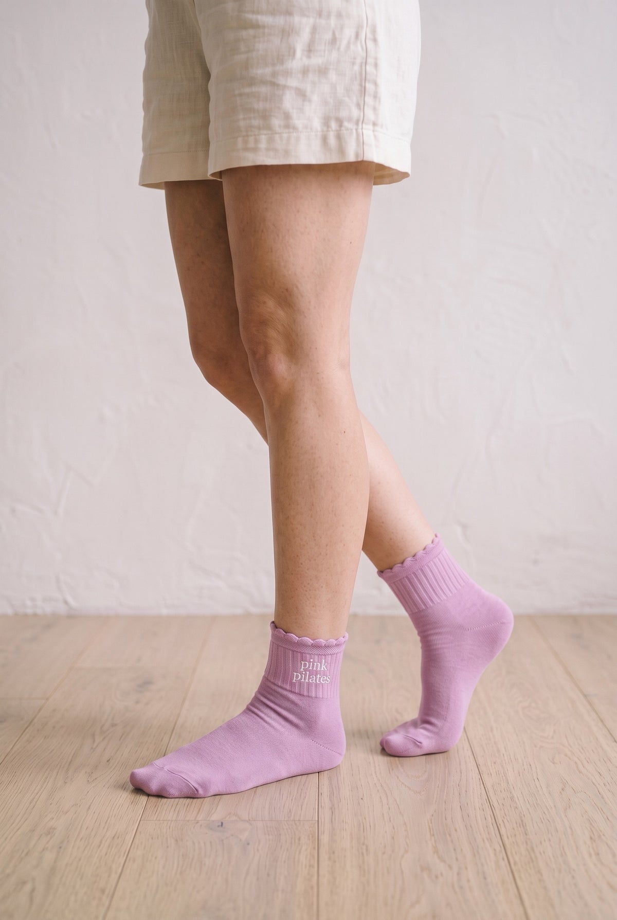 Model wearing orchid embroidered ruffle ankle socks, second view