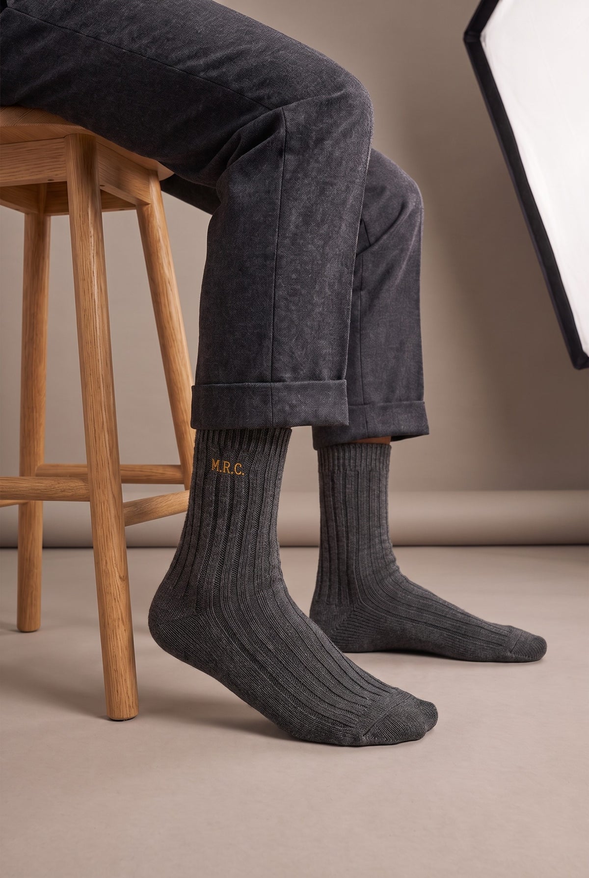 Model wearing charcoal embroidered men's wool socks