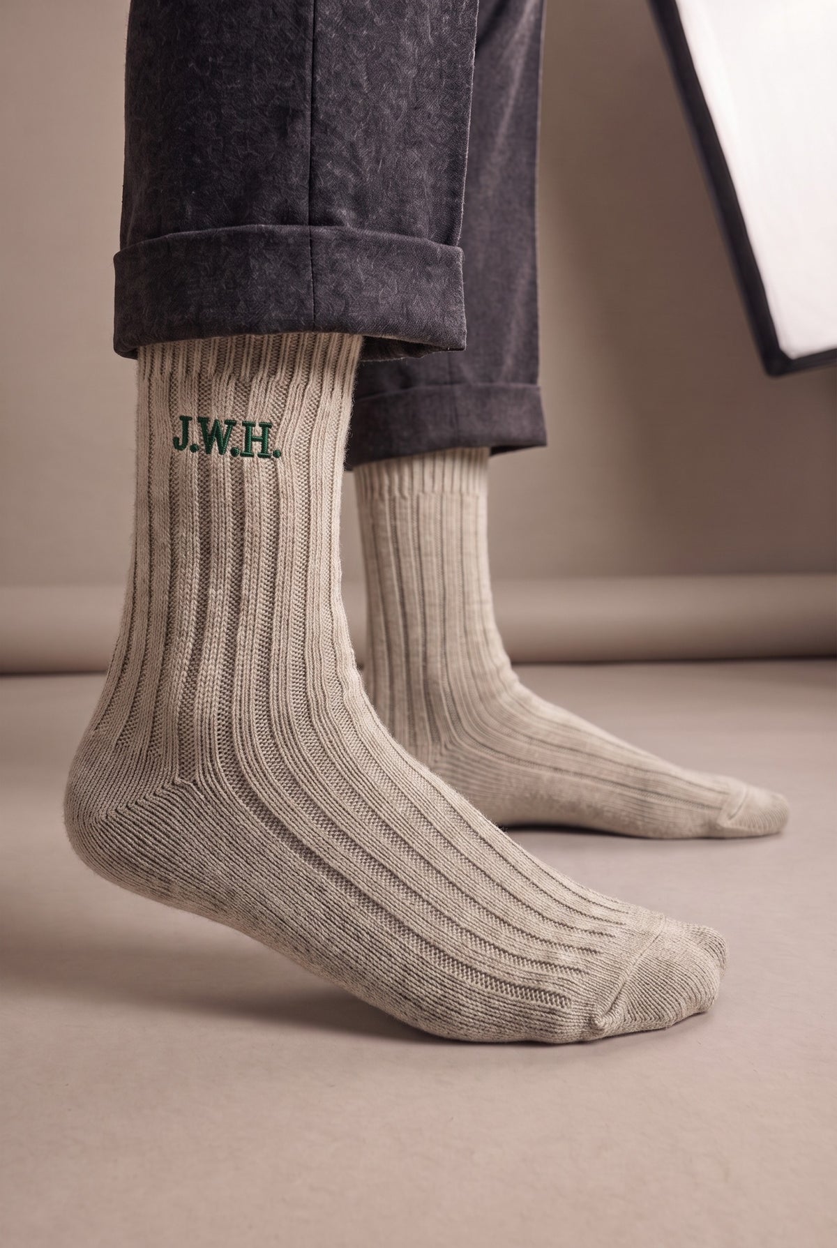 Model wearing beige embroidered men's wool socks, second view