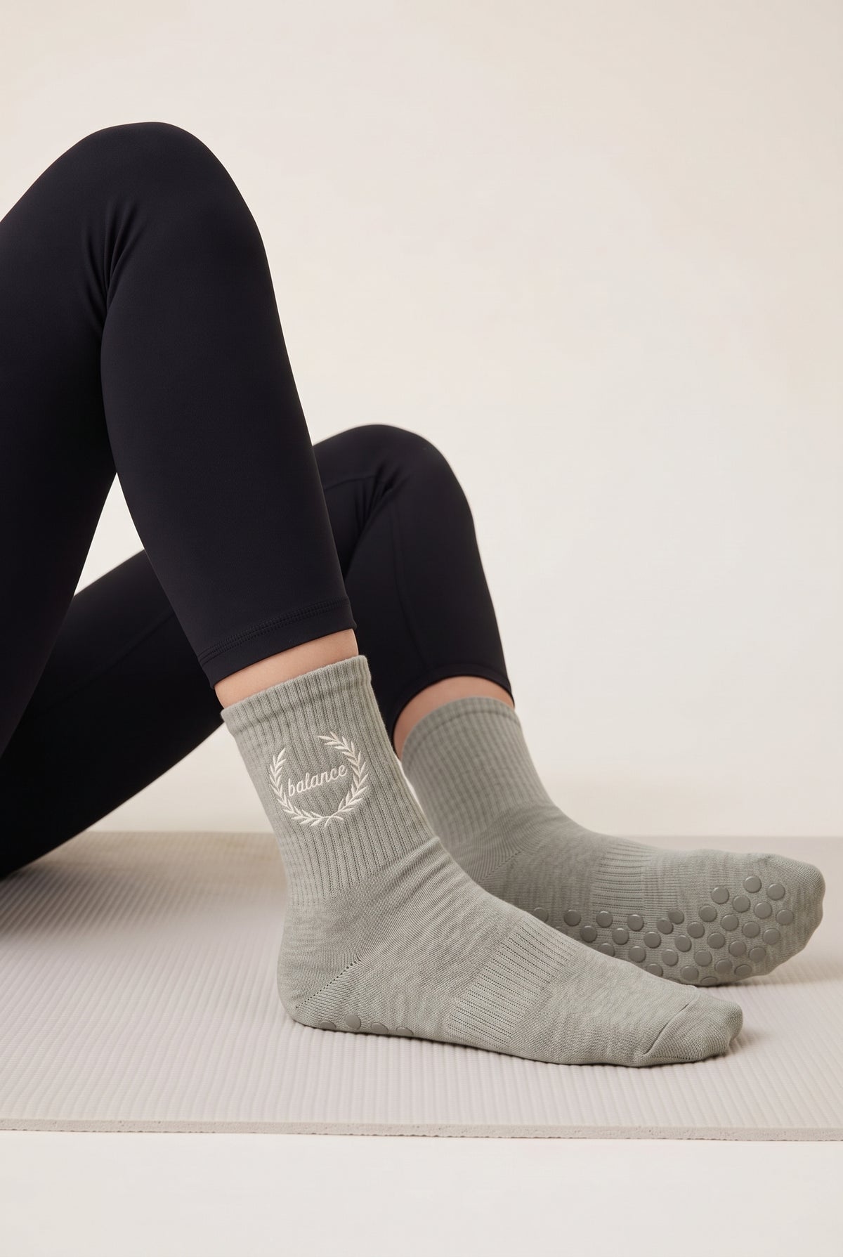 Model wearing khaki embroidered dot grip pilates socks