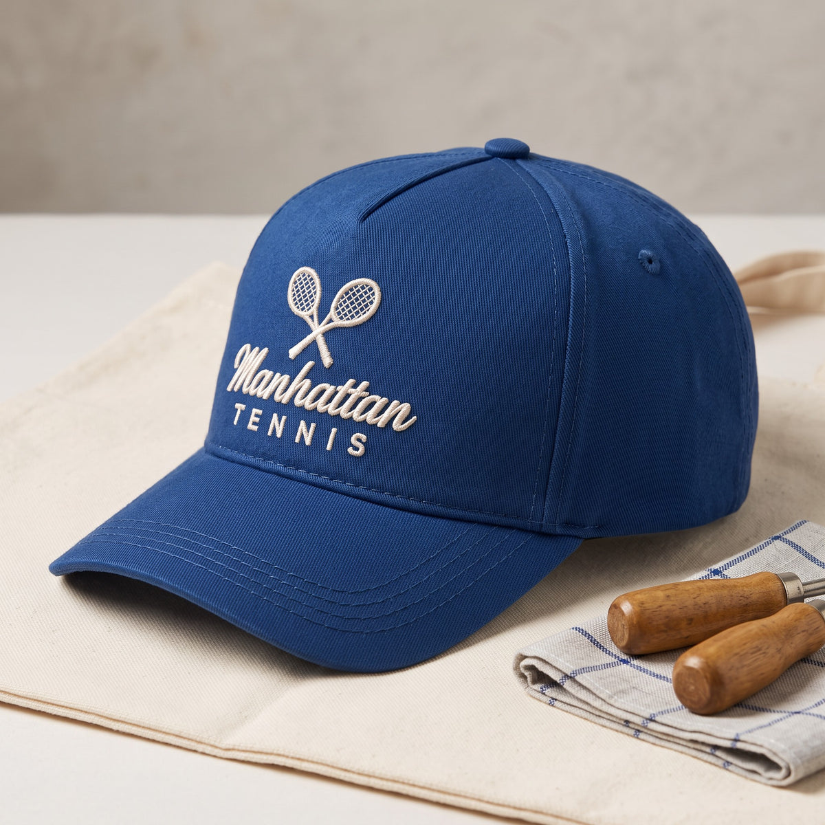Custom Tennis Cap styled flat lay, embroidery detail