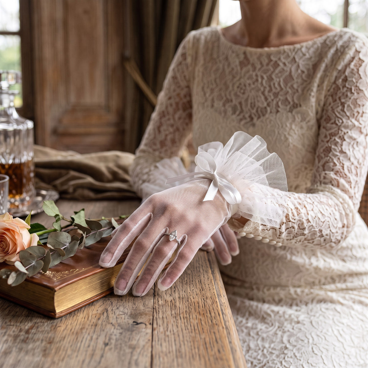Sheer white tulle wrist gloves with a pleated tulle ruffle cuff and a satin bow.