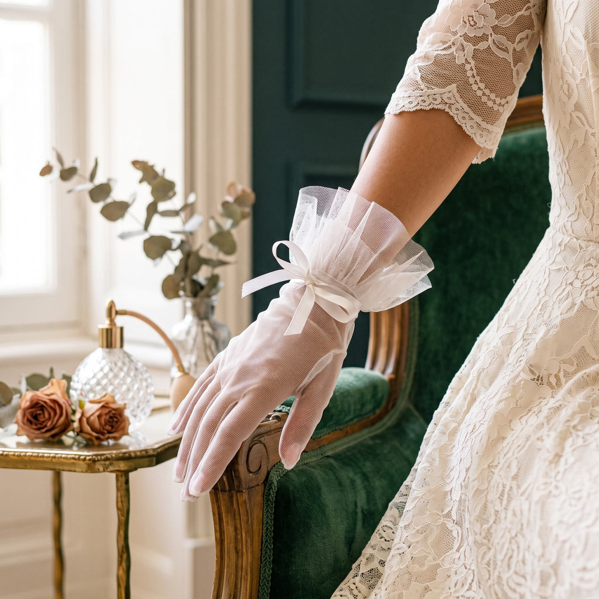 Sheer white tulle wrist gloves with a pleated tulle ruffle cuff and a satin bow.