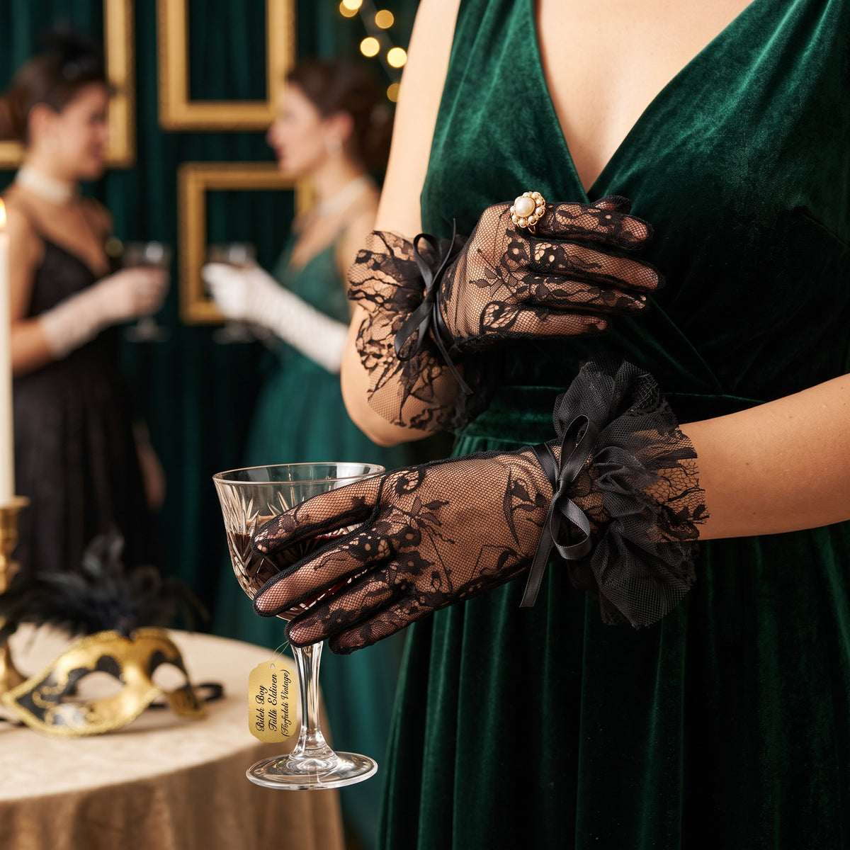 Black floral lace wrist gloves with a black tulle ruffle cuff and satin bow.