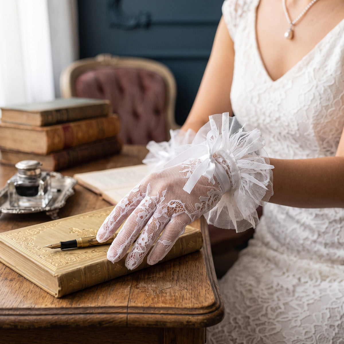 White scalloped lace wrist gloves with a compact pleated tulle rosette cuff.