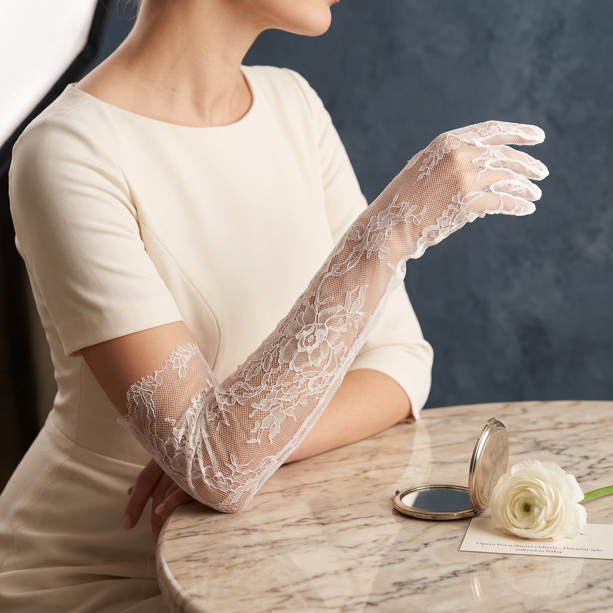 Above-elbow white Chantilly lace gloves with scalloped edges, fingers covered.