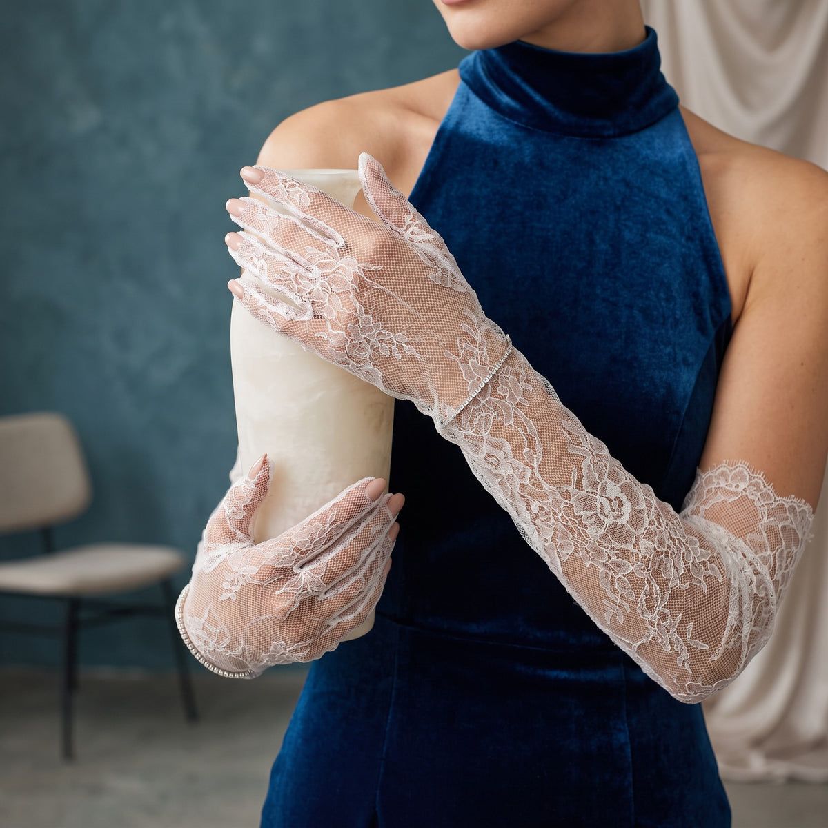 Above-elbow white Chantilly lace gloves with scalloped edges, fingers covered.