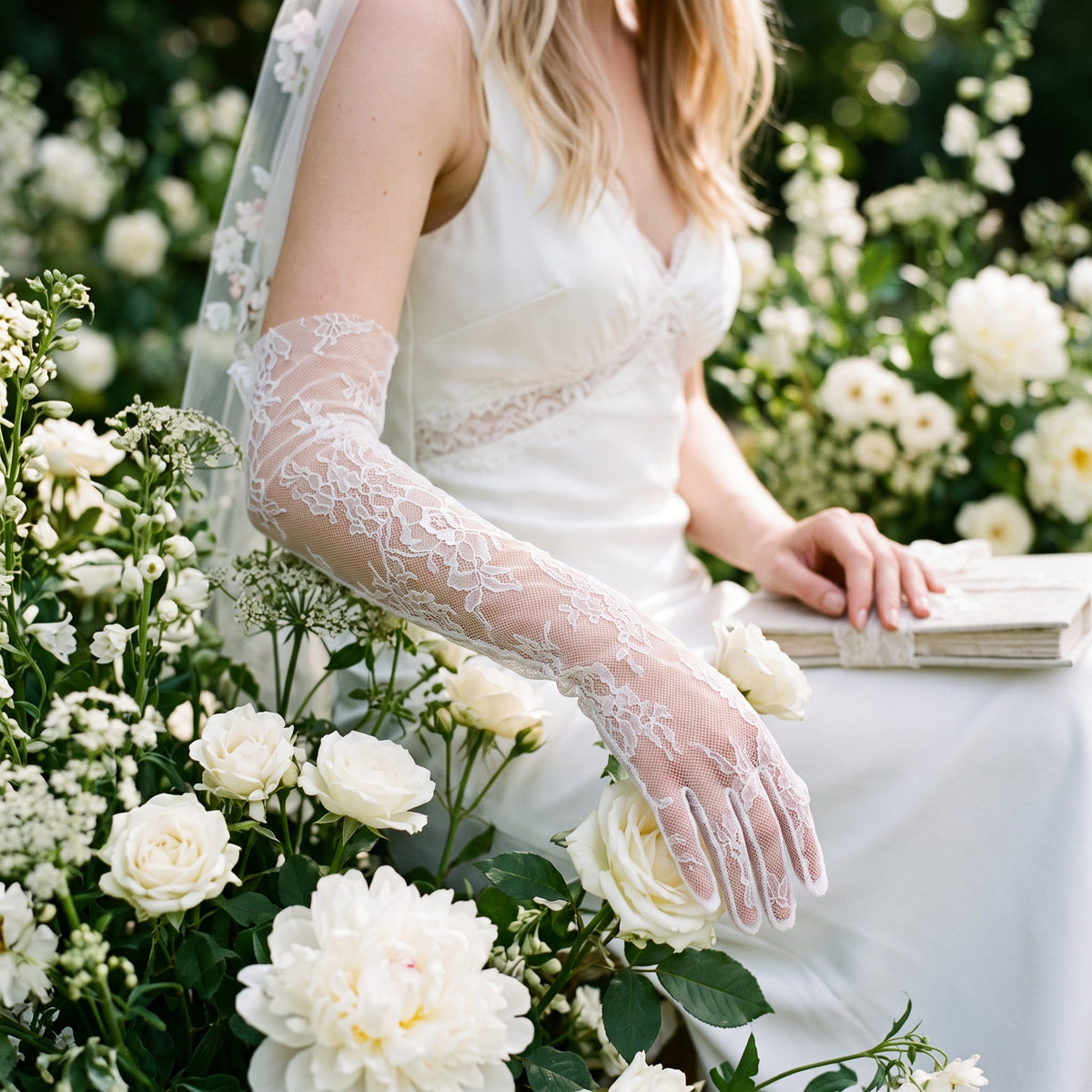 Above-elbow white Chantilly lace gloves with scalloped edges, fingers covered.