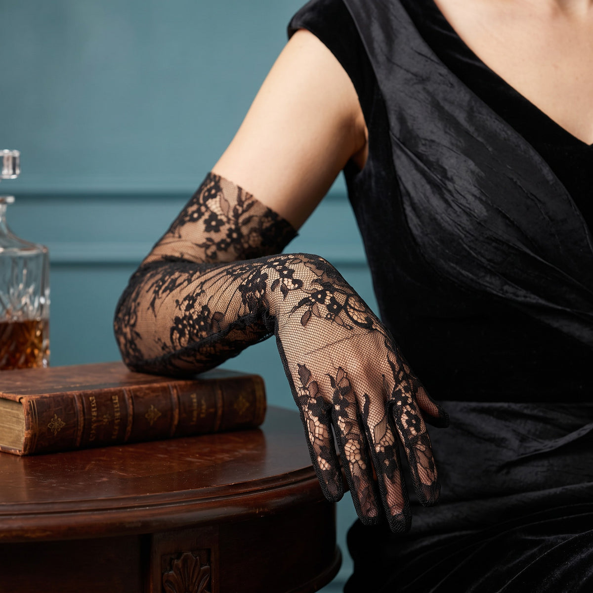 Above-elbow black floral lace gloves with scalloped fingertips.
