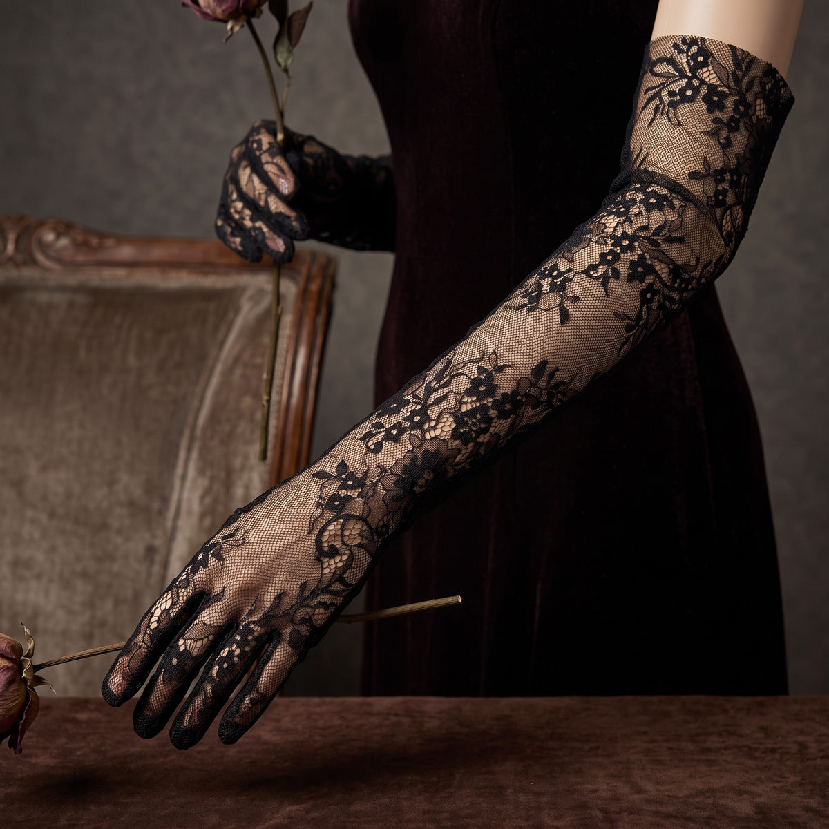Above-elbow black floral lace gloves with scalloped fingertips.
