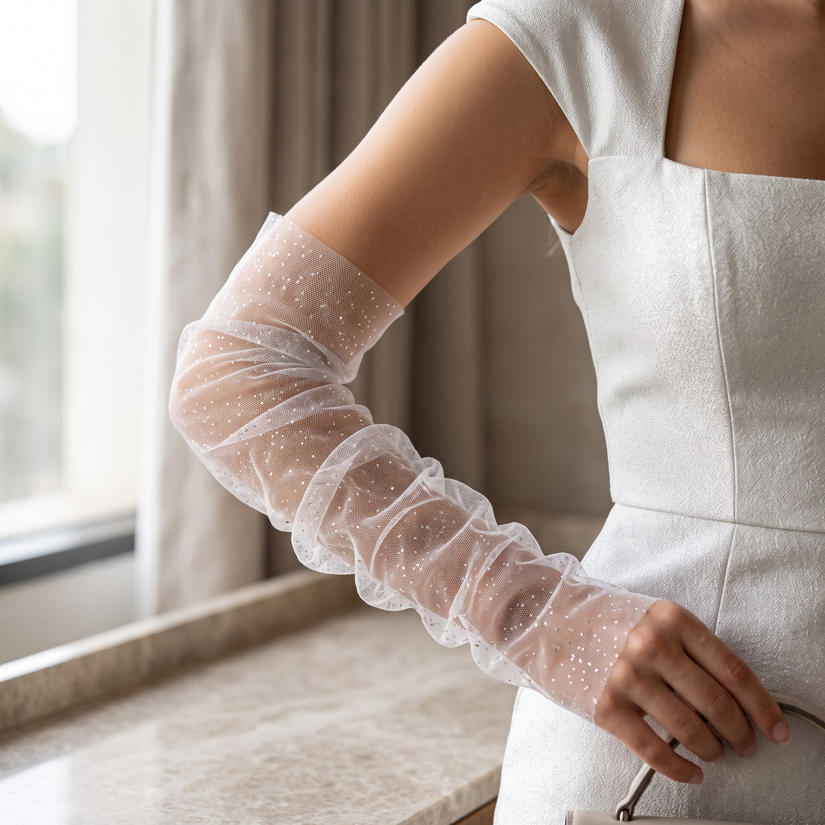 Ruched white tulle arm cuffs flecked with fine glitter, fingerless, ruffle edge.