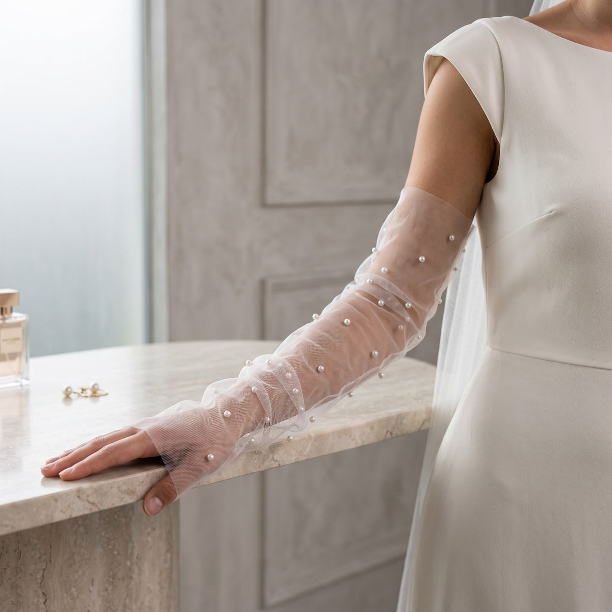 White tulle arm cuffs with small pearls scattered widely, fingerless, no ruffle.