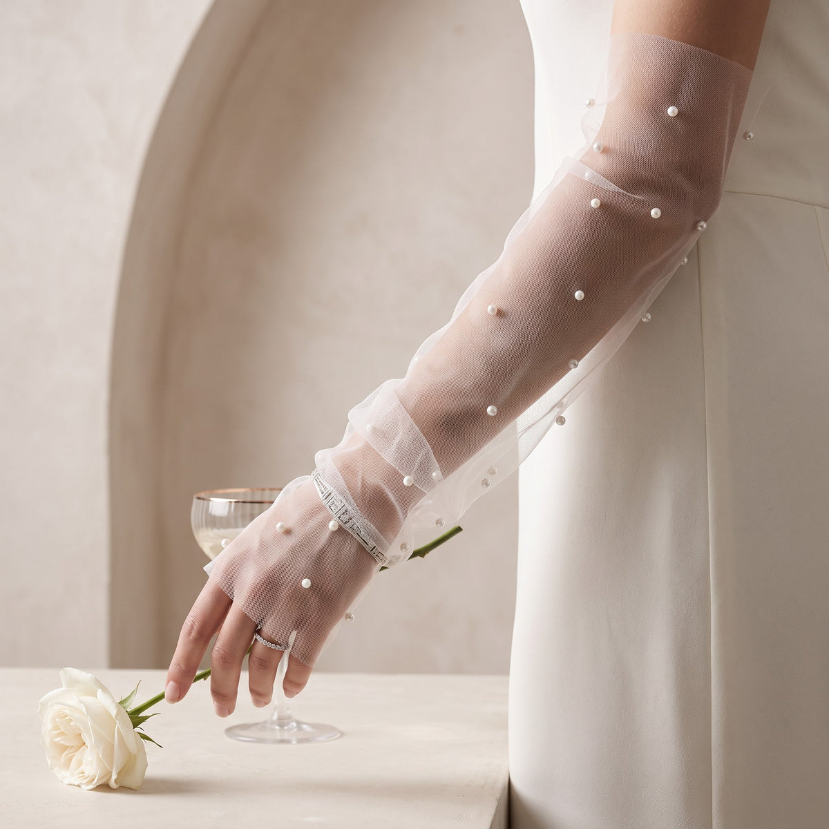 White tulle arm cuffs with small pearls scattered widely, fingerless, no ruffle.