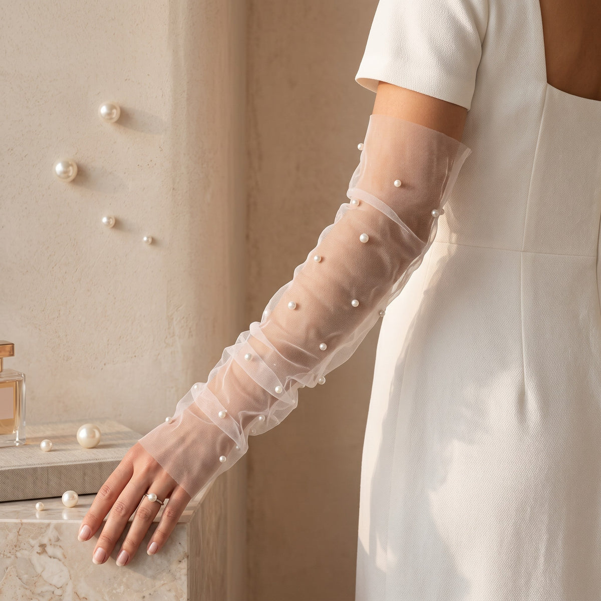 White tulle arm cuffs with small pearls scattered widely, fingerless, no ruffle.