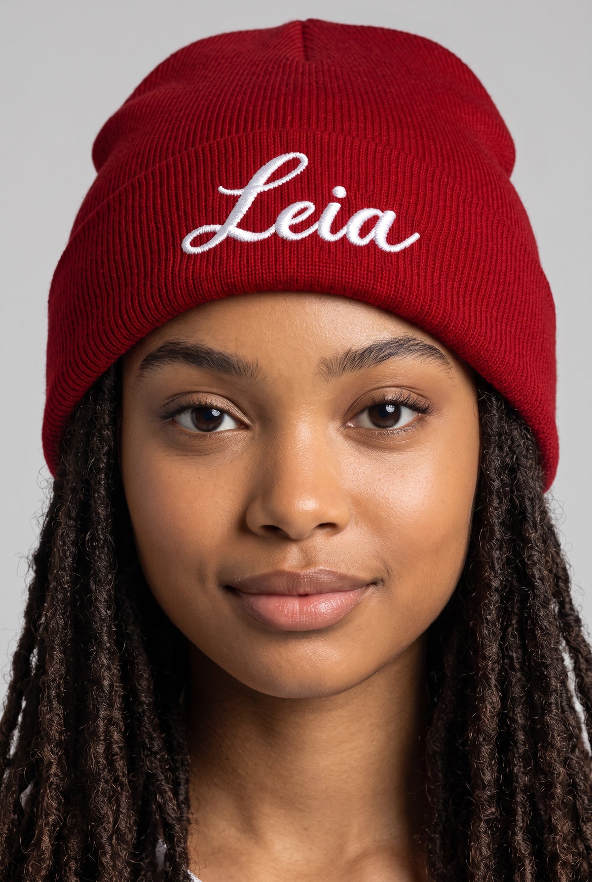 Model wearing a red Eddia beanie with custom cuff embroidery
