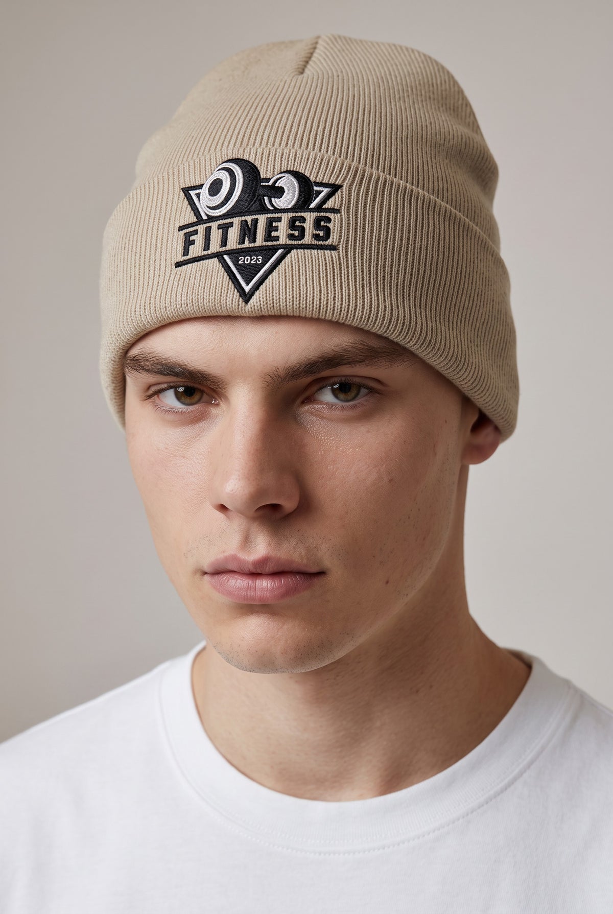 Model wearing a beige Eddia beanie with custom cuff embroidery