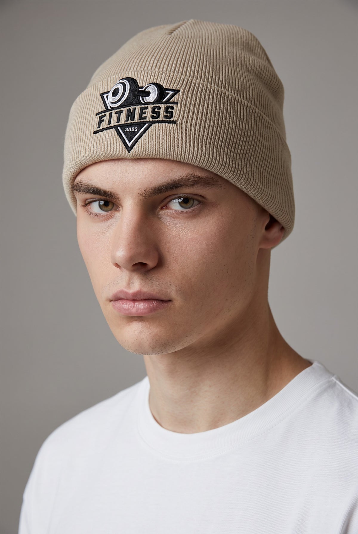 Model wearing a beige Eddia beanie with custom cuff embroidery