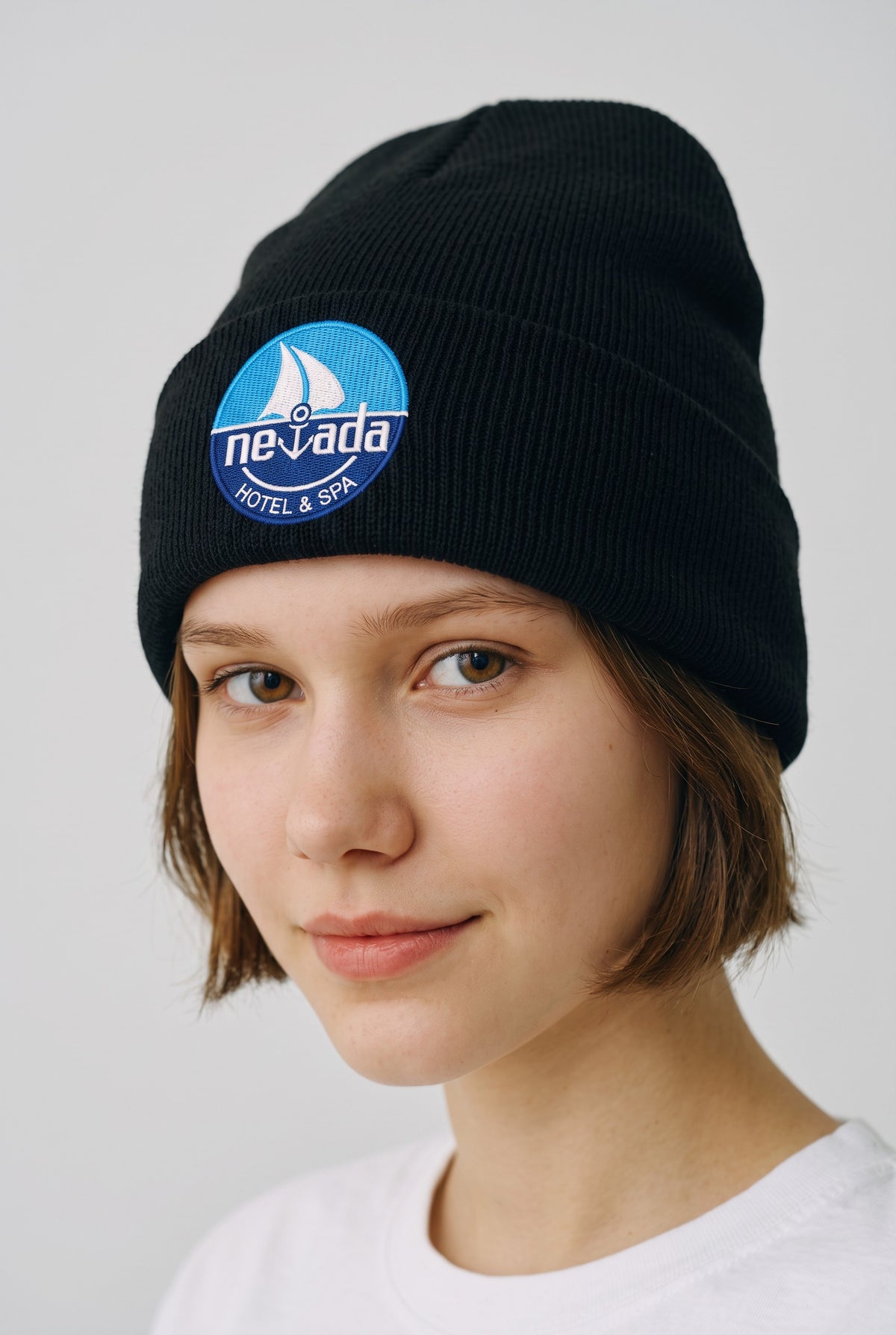 Model wearing a black Eddia beanie with custom cuff embroidery