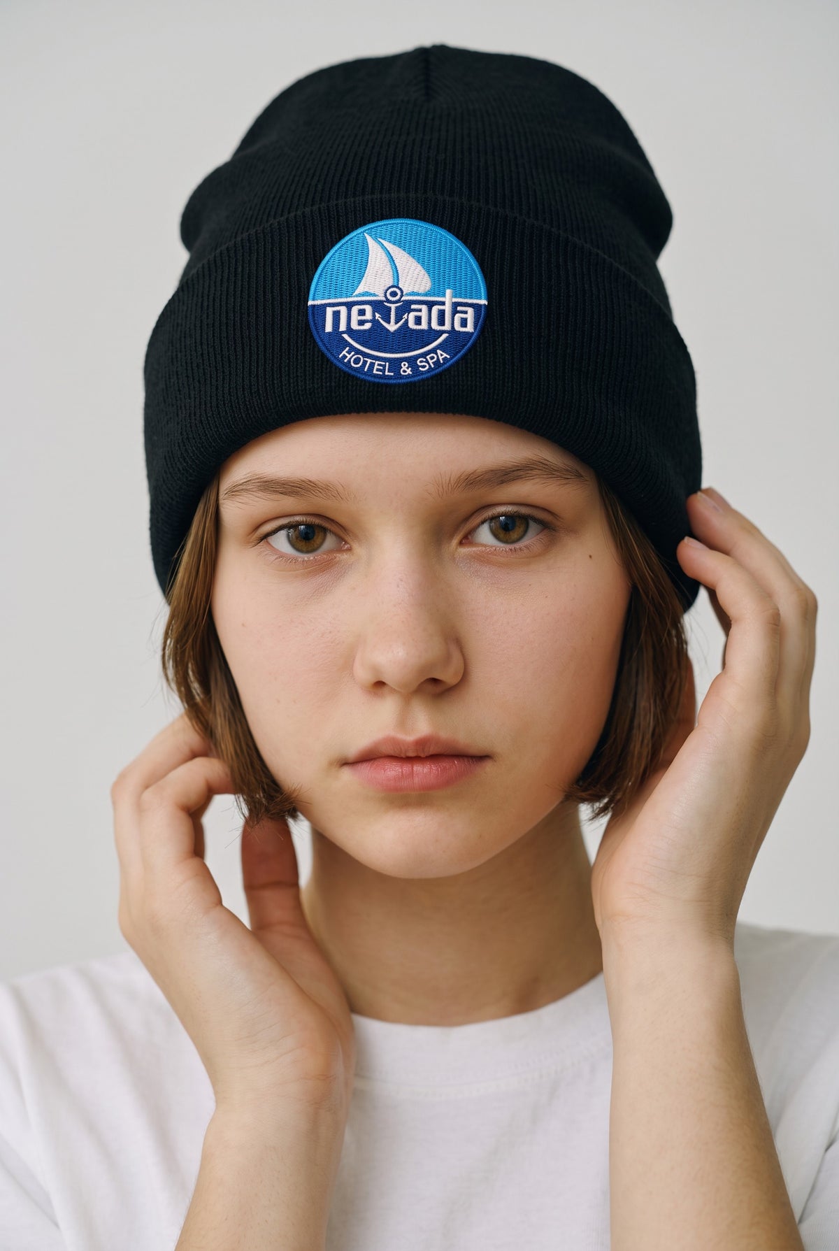 Model wearing a black Eddia beanie with custom cuff embroidery