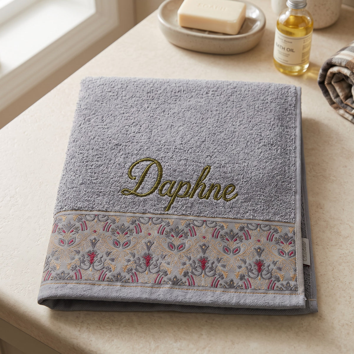 Daphne personalized hair towel, olive green script embroidery on light gray cotton with a patterned border — photo 3