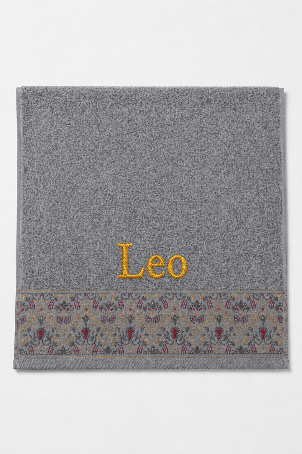Leo personalized hair towel, gold serif embroidery on light gray cotton with a patterned border