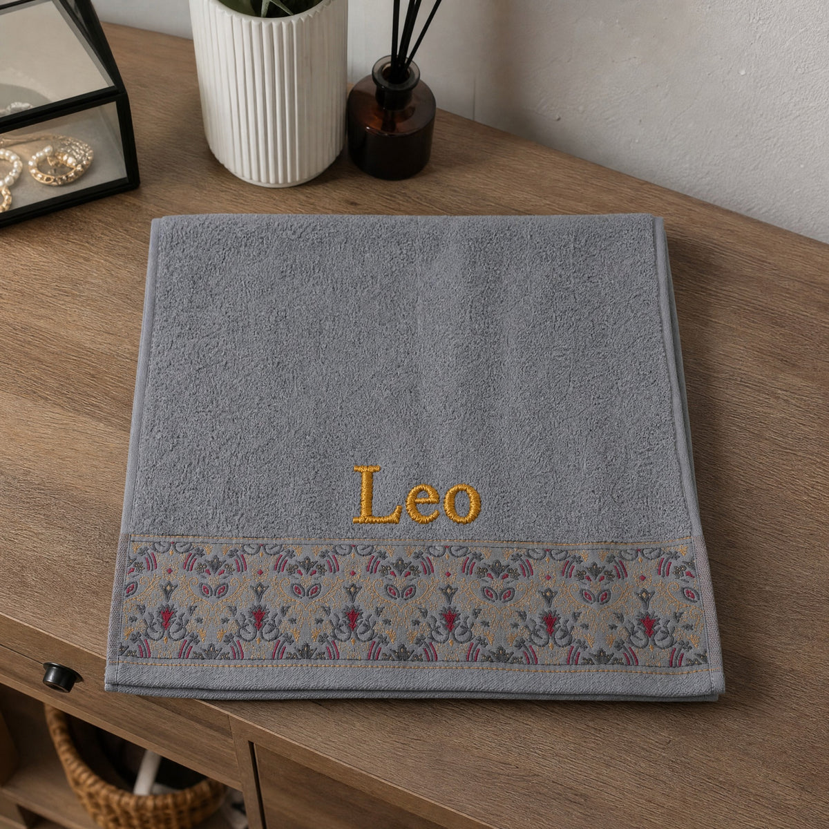 Leo personalized hair towel, gold serif embroidery on light gray cotton with a patterned border — photo 4