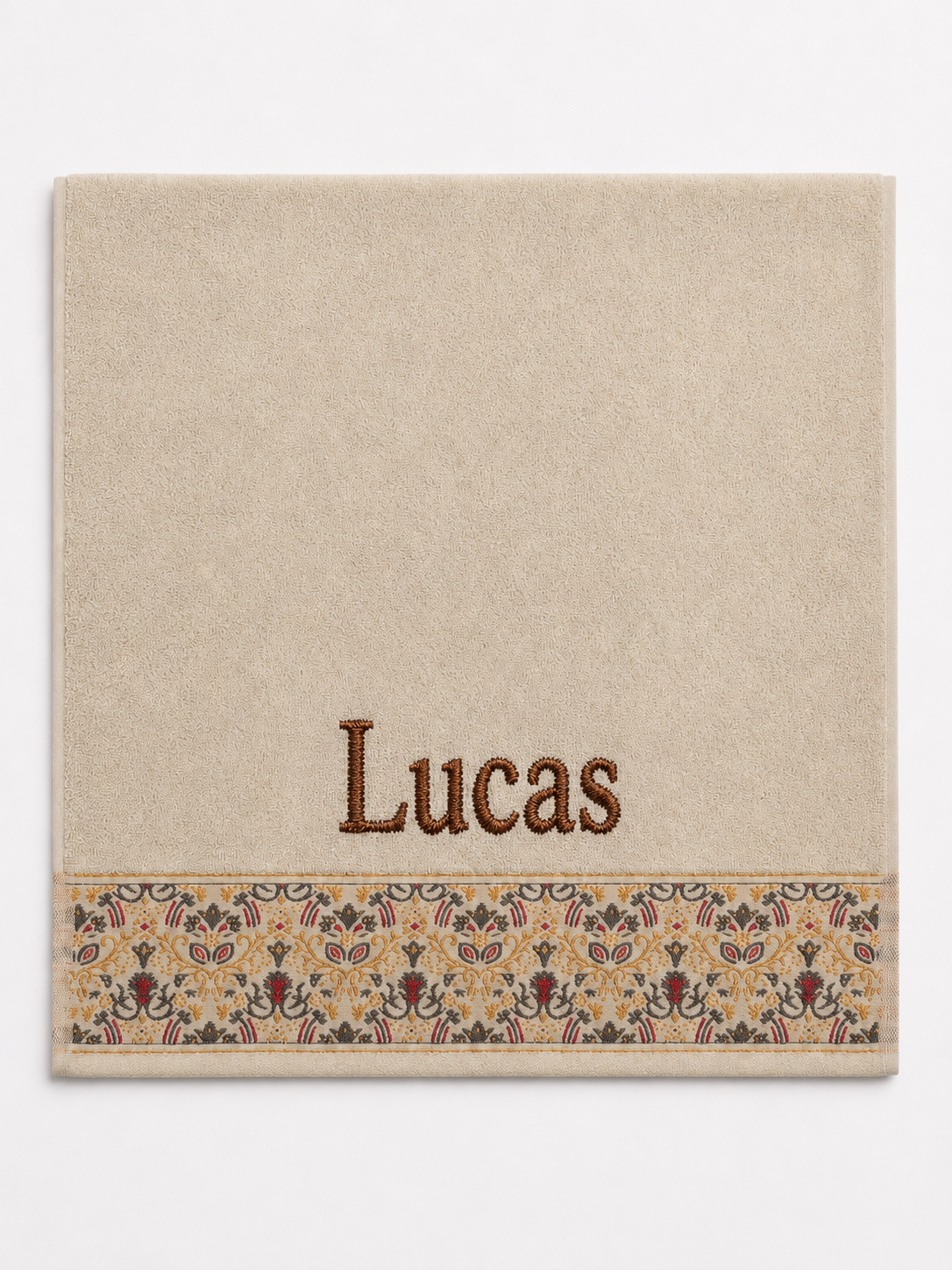 Lucas personalized hair towel, brown serif embroidery on cream cotton with a patterned border