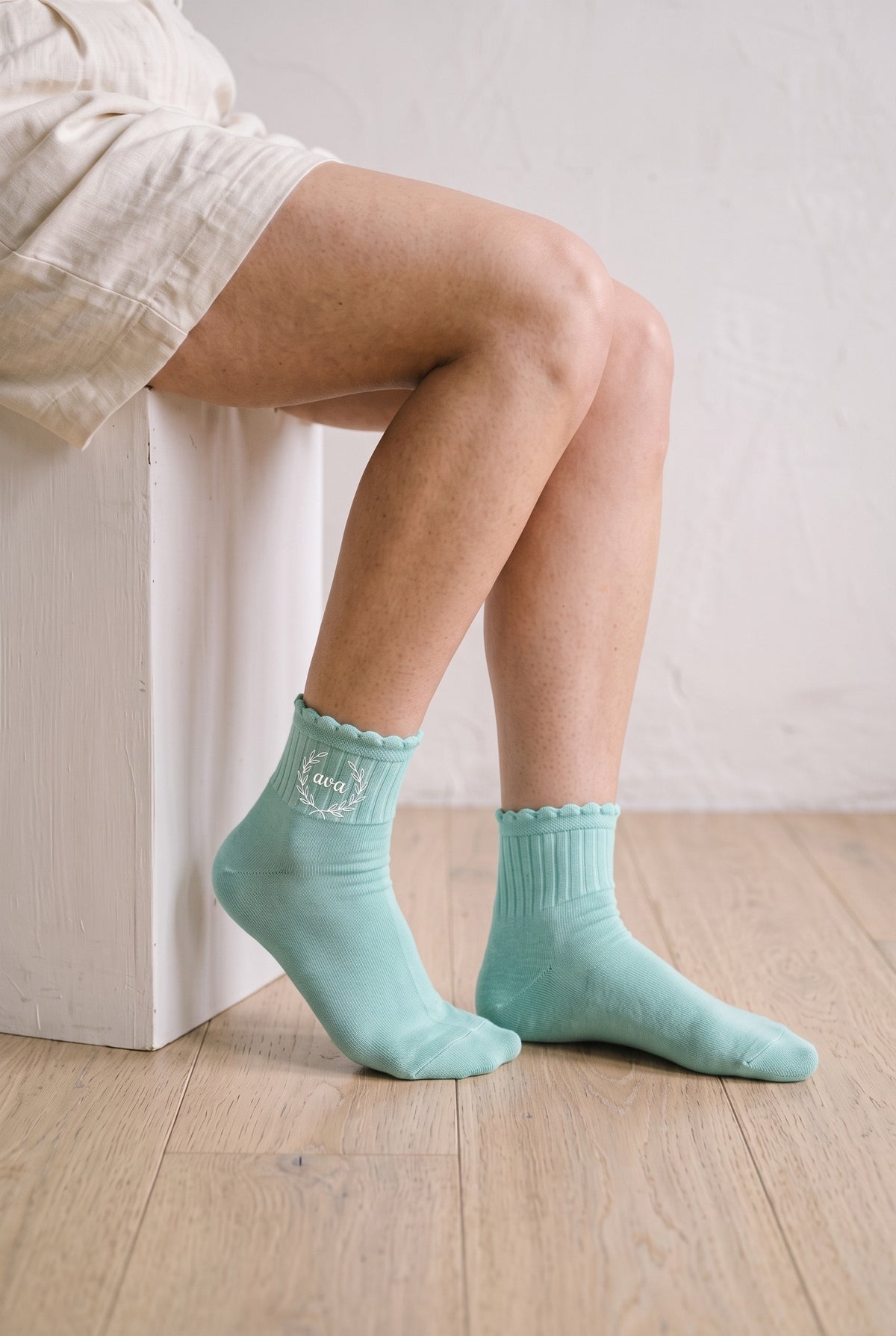 Model wearing mint embroidered ruffle ankle socks