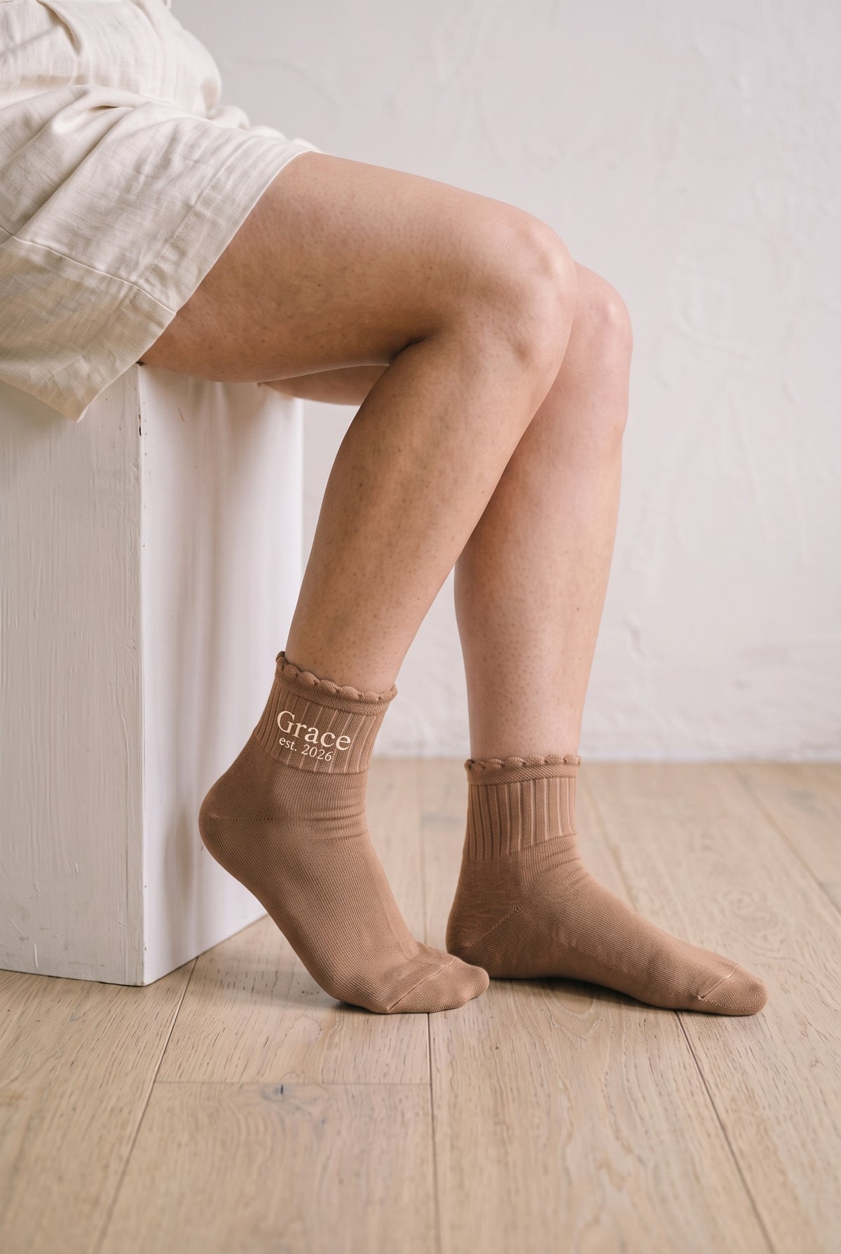 Model wearing camel embroidered ruffle ankle socks