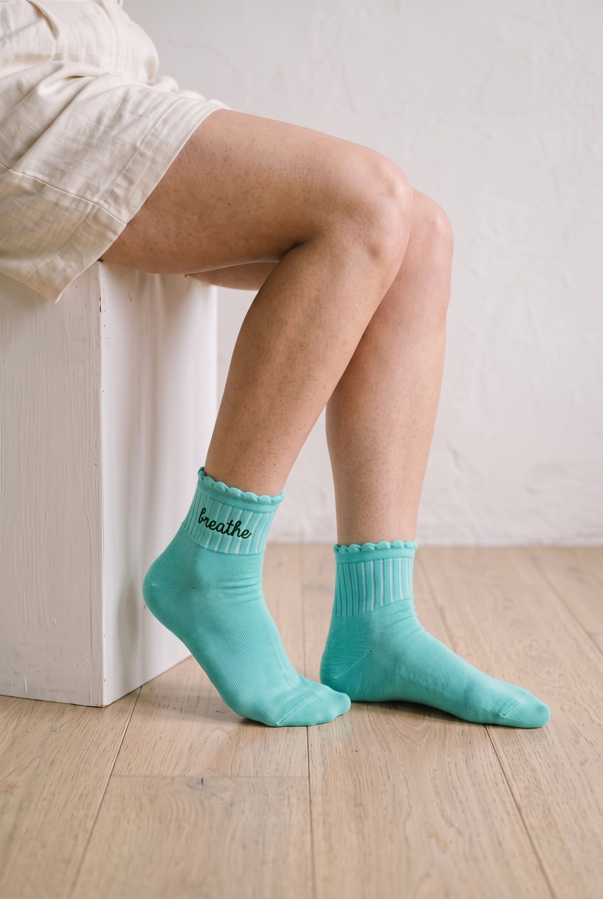 Model wearing light mint embroidered ruffle ankle socks