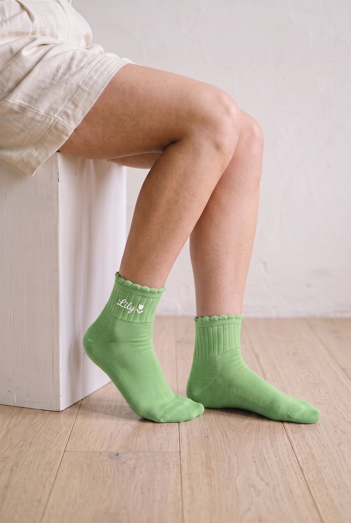 Model wearing pistachio green embroidered ruffle ankle socks