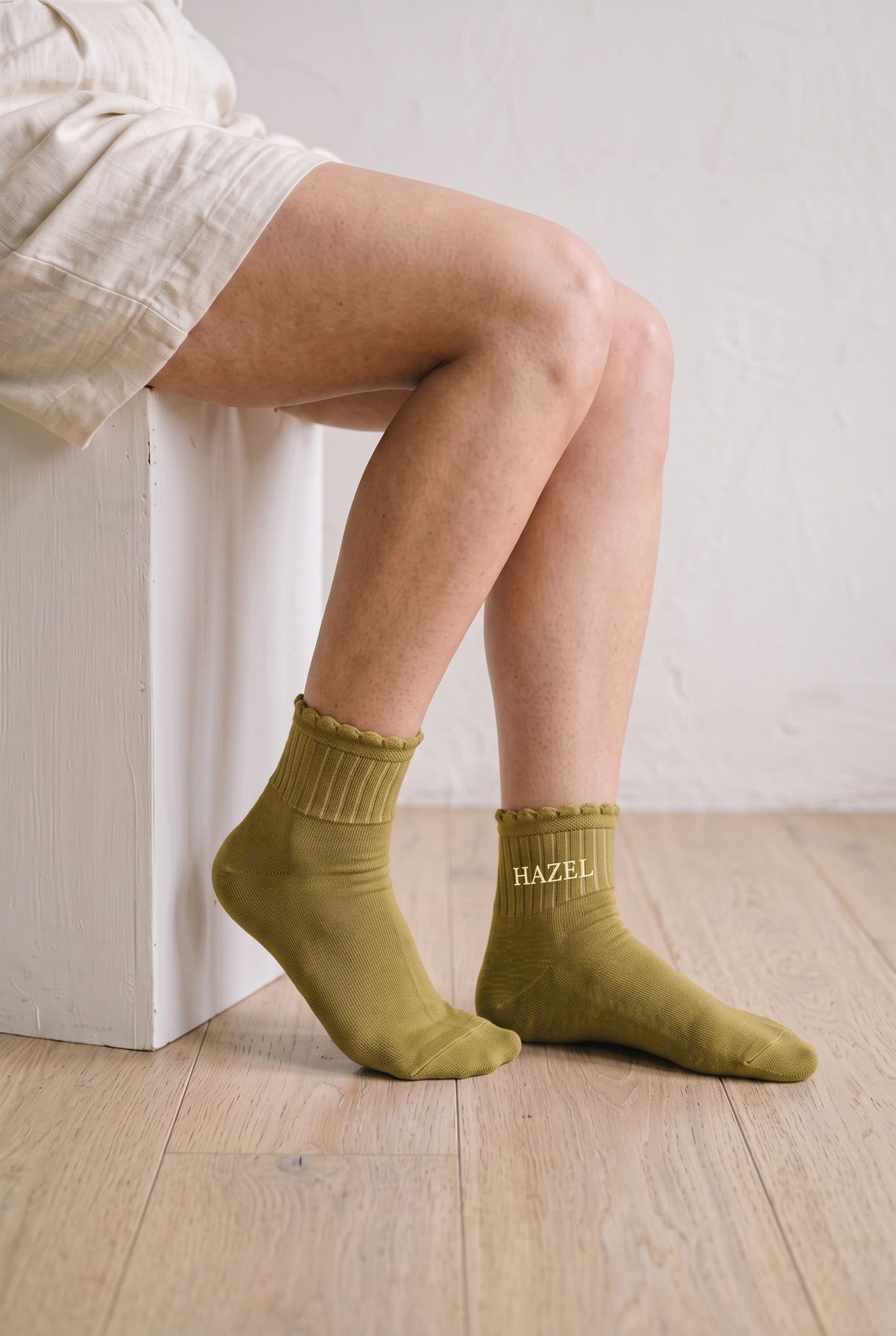 Model wearing mustard yellow embroidered ruffle ankle socks